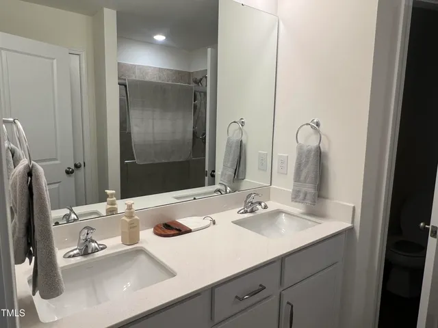 a bathroom with double sink and a mirror