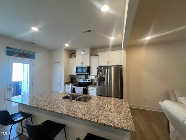 a kitchen with stainless steel appliances granite countertop a sink refrigerator and microwave