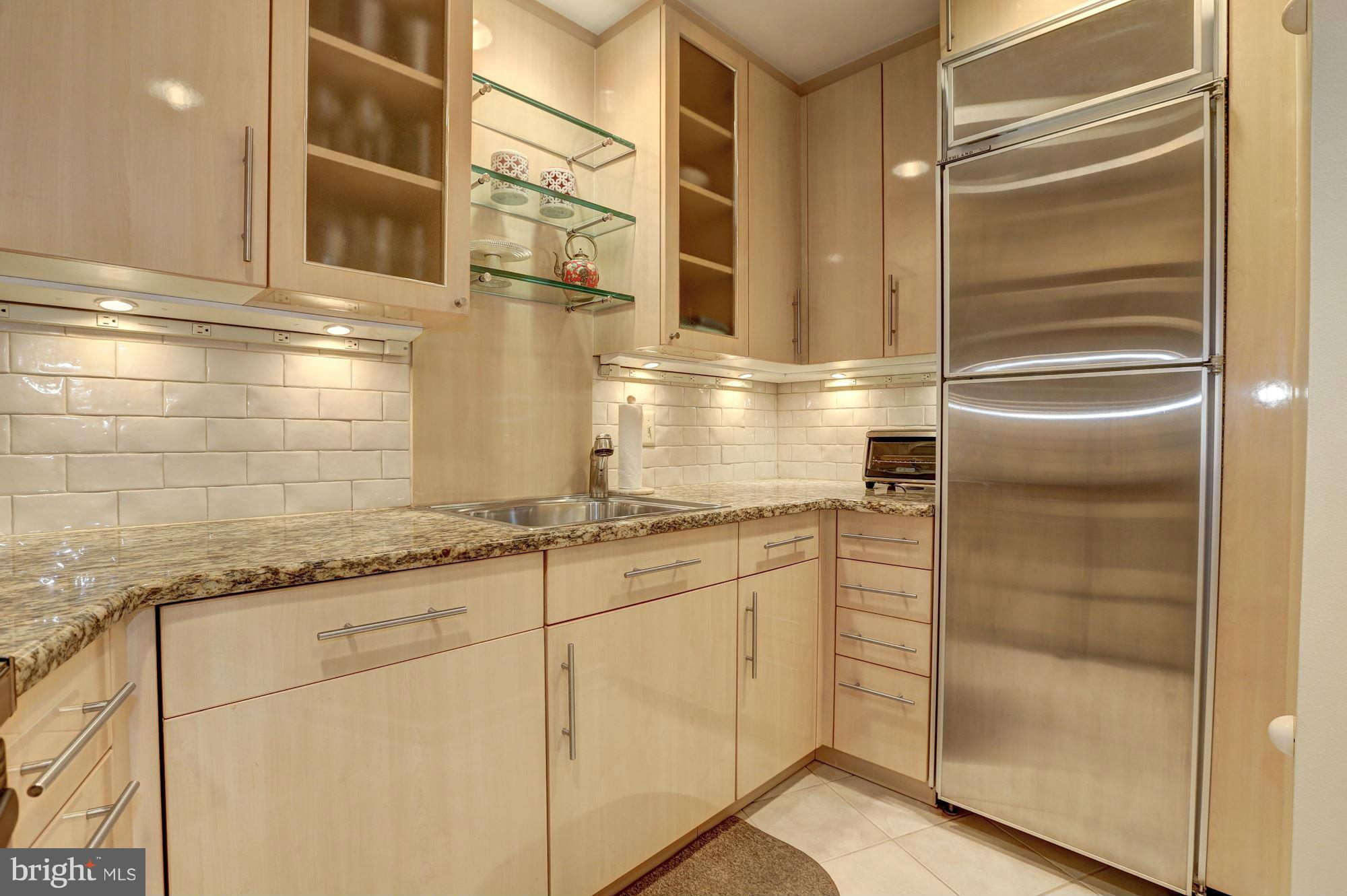 3 Washington Circle Northwest, Unit 103 Washington, DC 20037 - Photo 9 of 28 a kitchen with granite countertop white cabinets and white appliances