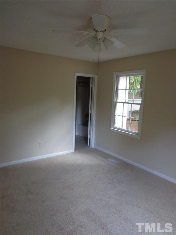 3616 Lynn Road Raleigh, NC 27613 - Photo 11 of 12 an empty room with a chandelier fan and windows