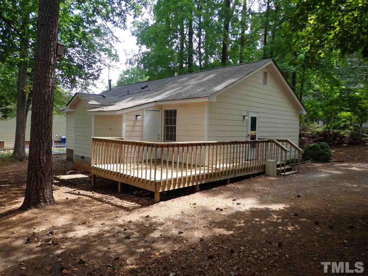 3616 Lynn Road Raleigh, NC 27613 - Photo 5 of 12 a view of a house with a yard deck and a forest