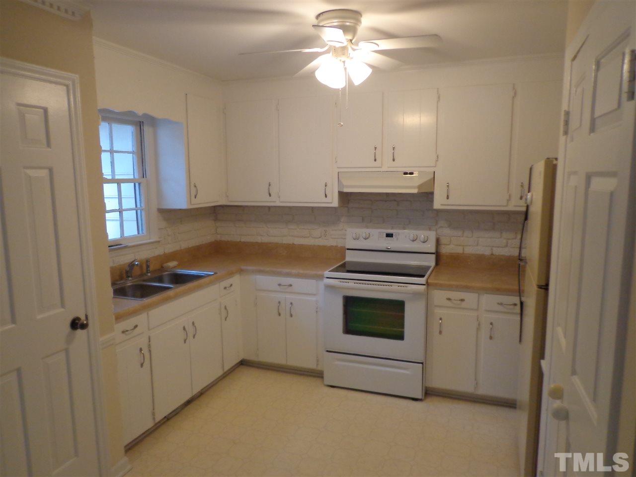 3616 Lynn Road Raleigh, NC 27613 - Photo 7 of 12 a kitchen with granite countertop a sink stainless steel appliances and white cabinets