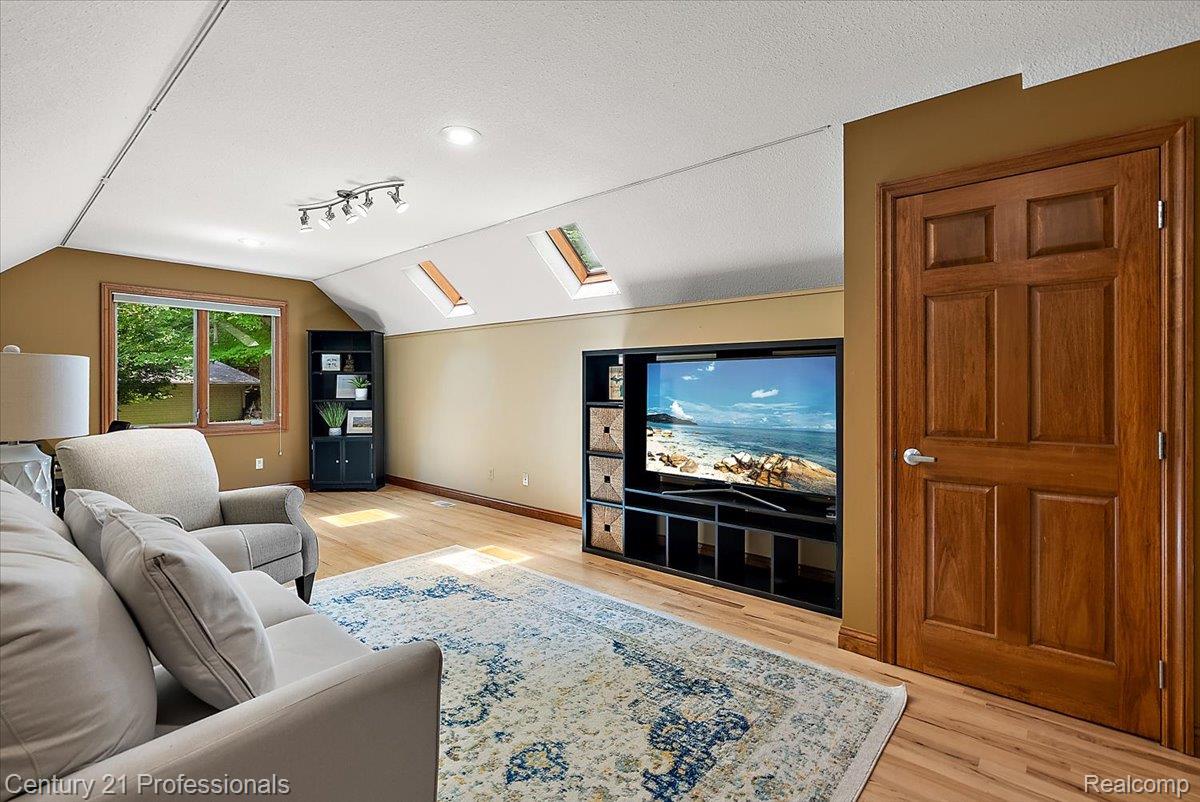 9867 Rainbow Ridge Drive Schoolcraft, MI 49087 - Photo 45 of 82 Wood-finish flooring throughout this room, featuring a built-in media center, skylight windows, and a four-panel wooden door