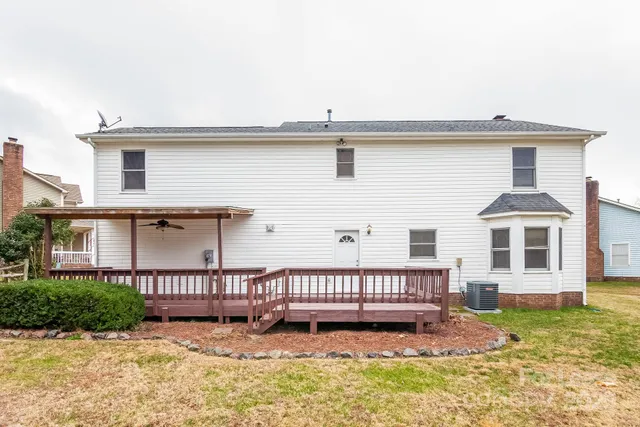 a view of a house with wooden deck and a yard