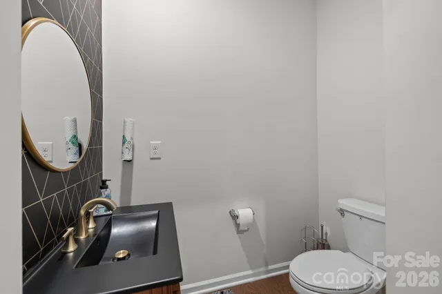 a bathroom with a toilet a sink and mirror