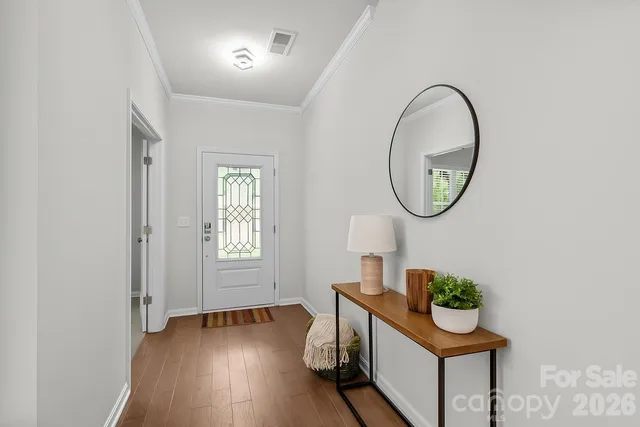 an entryway with wooden floor mirror and a sink