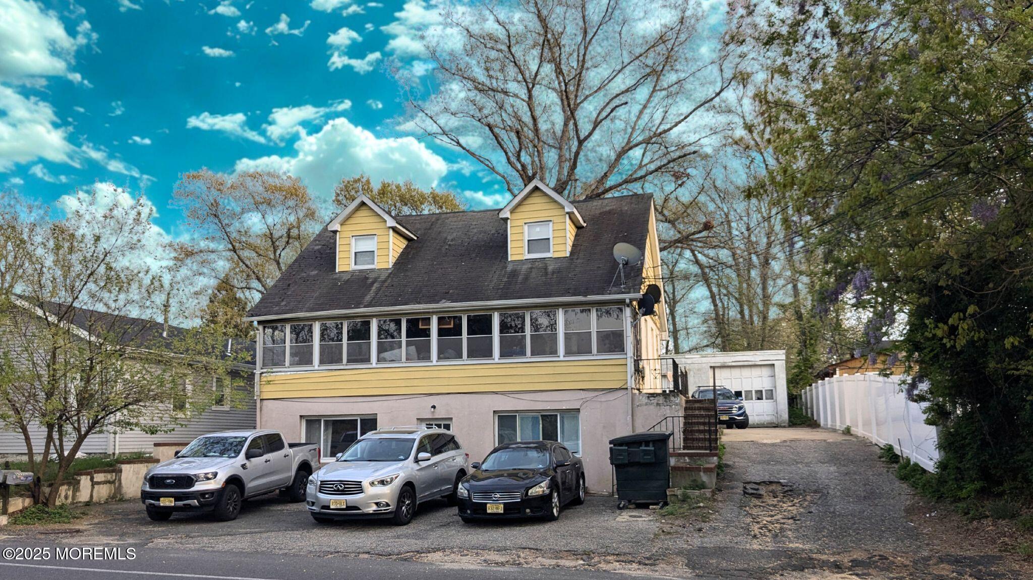 a front view of a building with cars parked