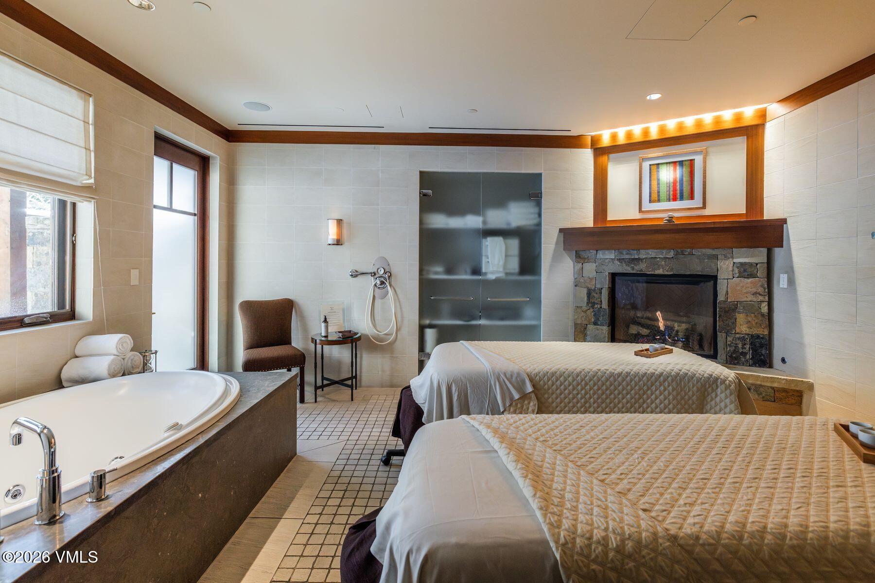 1 Vail Road, Unit 9204 Vail, CO 81657 - Photo 25 of 27 a spacious bedroom with a bed and a fireplace