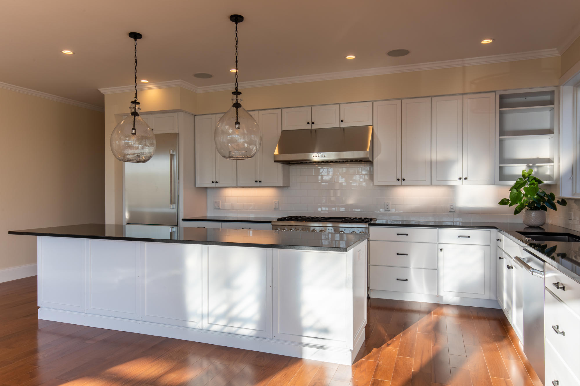 18 Paddock Road Oak Bluffs, MA 02557 - Photo 6 of 7 a kitchen with stainless steel appliances granite countertop a sink a refrigerator a stove and white cabinets with wooden floor