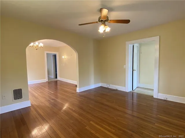 a view of an empty room with wooden floor