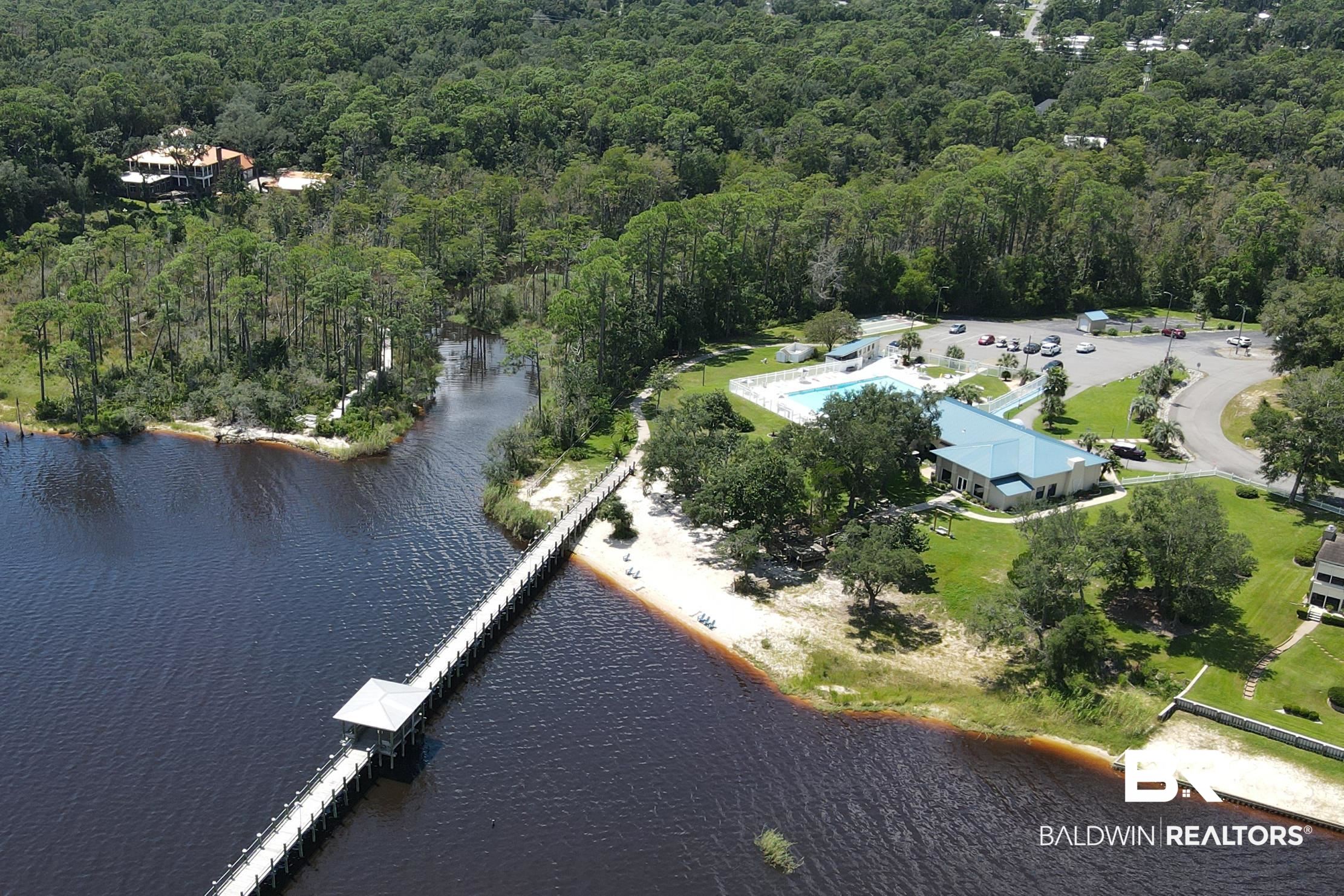84 Horn Drive Lillian, AL 36549 - Photo 20 of 24 Aerial view of property's location with a heavily wooded area, a nearby body of water, and a pool area