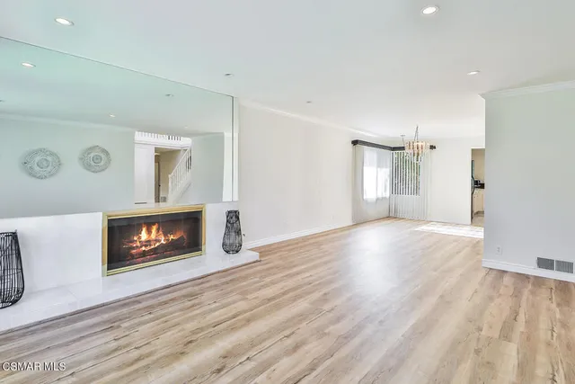 a view of a room with wooden floor staircase and front door