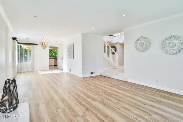 a kitchen with stainless steel appliances granite countertop white cabinets and a window