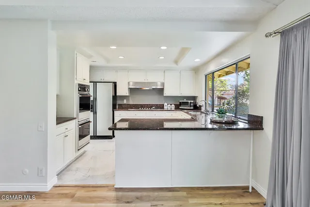 a kitchen with stainless steel appliances granite countertop a sink a stove and a microwave