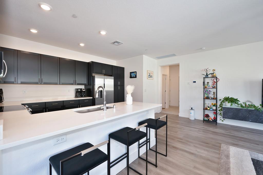 5301 East Commerce Way, Unit 32101 Sacramento, CA 95835 - Photo 15 of 41 a living room with stainless steel appliances kitchen island granite countertop furniture and a wooden floor