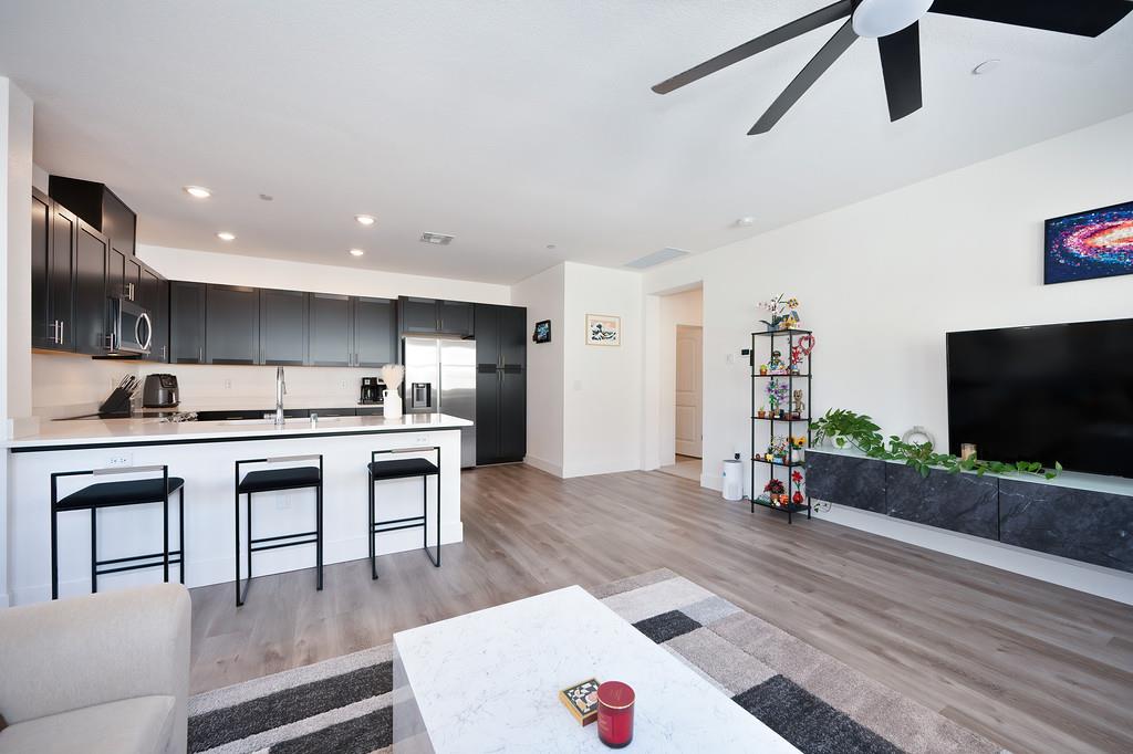 5301 East Commerce Way, Unit 32101 Sacramento, CA 95835 - Photo 18 of 41 a living room with stainless steel appliances kitchen island granite countertop furniture and a flat screen tv