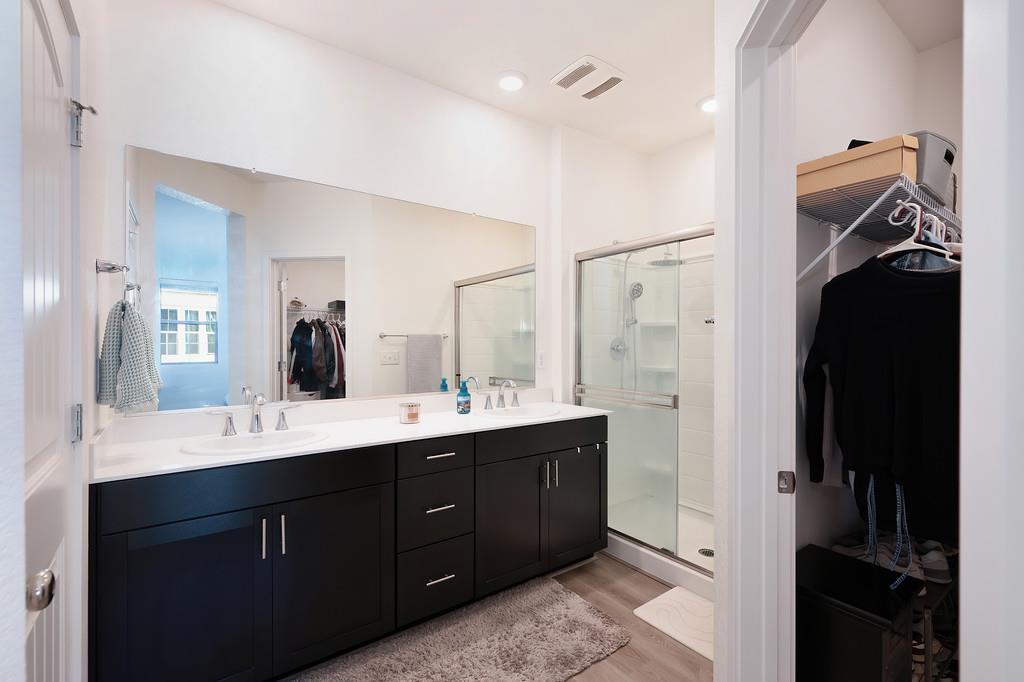 5301 East Commerce Way, Unit 32101 Sacramento, CA 95835 - Photo 34 of 41 a en suite bathroom with a double vanity sink a mirror and a shower
