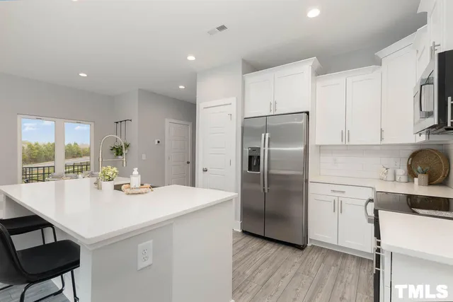 a kitchen with a sink a refrigerator and cabinets
