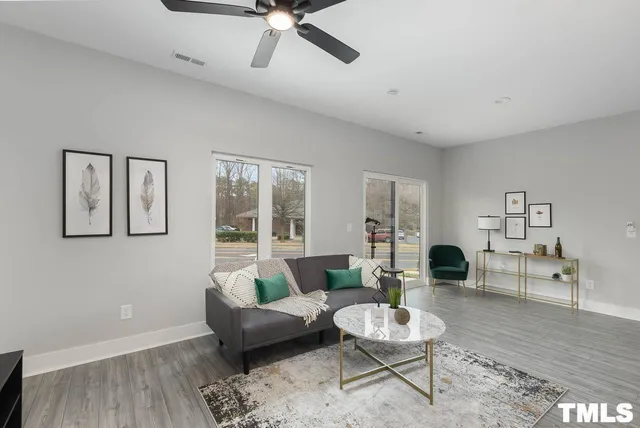 a living room with furniture and a wooden floor