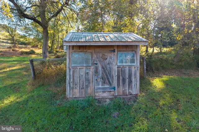a view of a house with a small yard and wooden fence