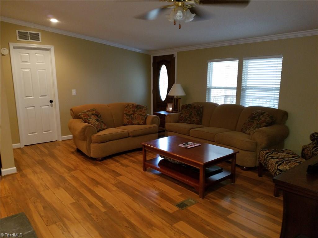 344 Prison Camp Road Dobson, NC 27017 - Photo 17 of 28 LARGE LIVING ROOM- NEW WOOD FLOORS- NEW WINDOWS AND NEW RESIDENTIAL DOORS AND CASINGS- CROWN MOLD AND BASEBOARDS