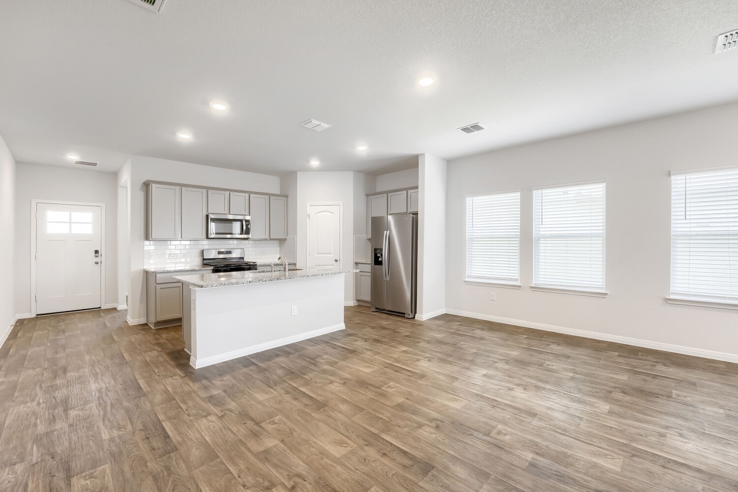 13507 Howser Trace Manor, TX 78653 - Photo 4 of 28 An open-concept living area boasts a modern kitchen with a spacious island, perfect for entertaining.