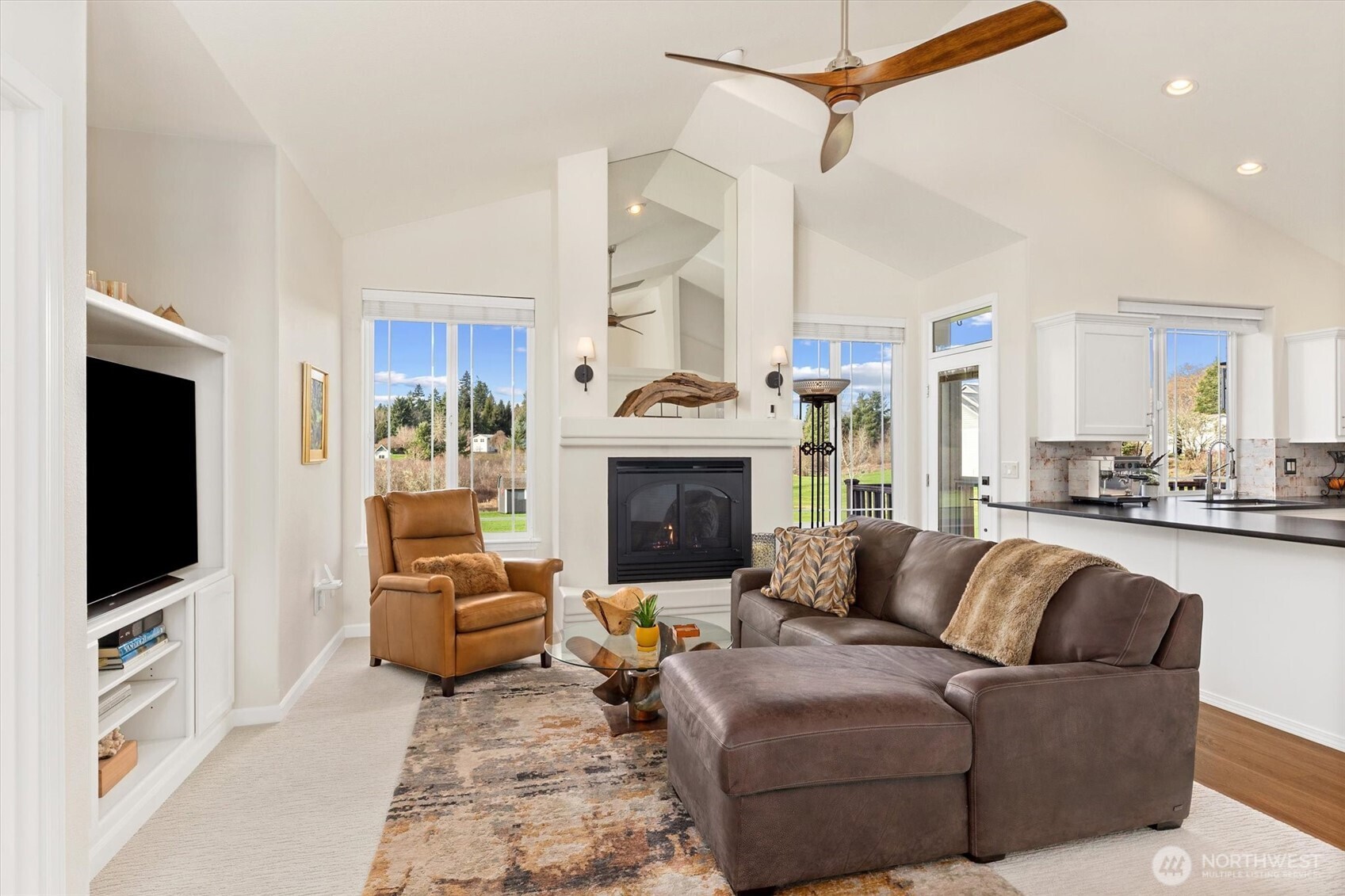 4946 Pleasant Glade Road Northeast Olympia, WA 98516 - Photo 7 of 38 a living room with furniture a flat screen tv and a fireplace