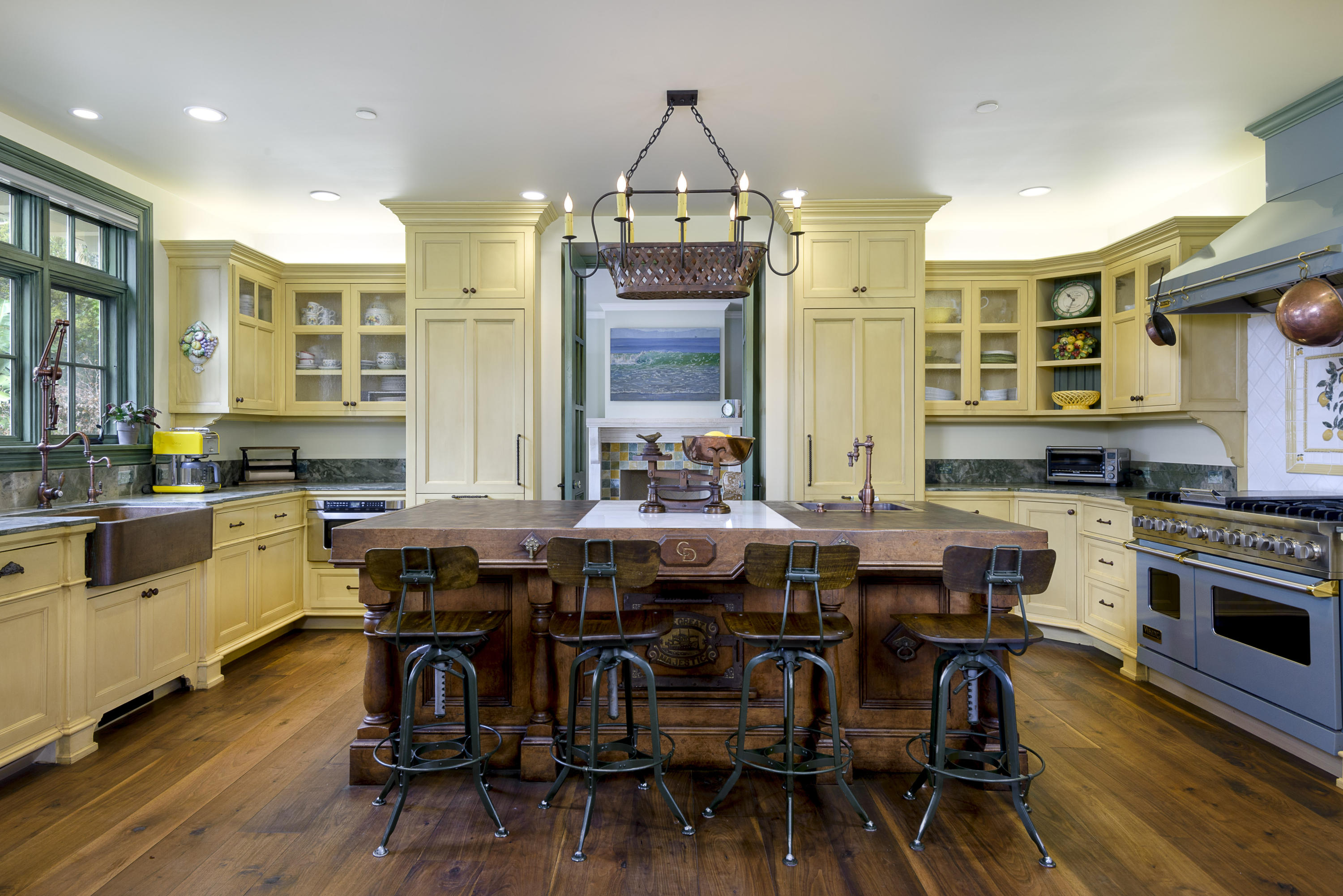 495 Toro Canyon Road Santa Barbara, CA 93108 - Photo 4 of 17 a kitchen with stainless steel appliances a stove a sink dishwasher a dining table and chairs with wooden floor