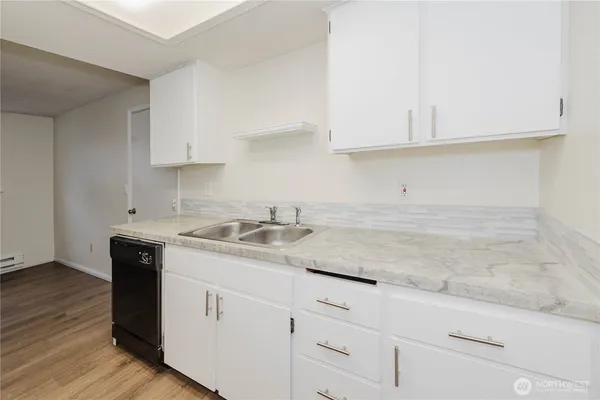 a kitchen with granite countertop white cabinets and a sink
