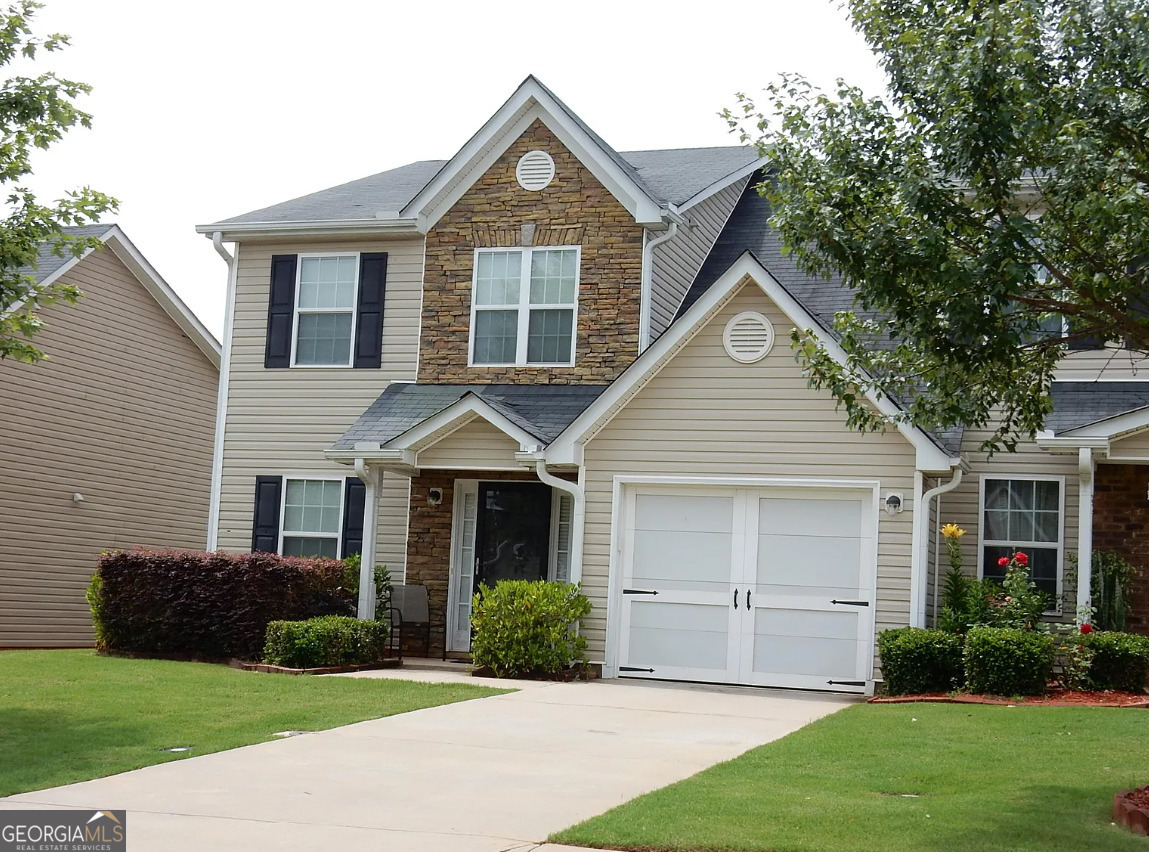 a front view of a house with a yard and garage