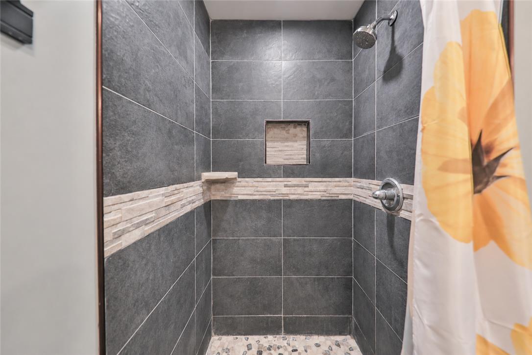24 Turkey Ridge Road East Stroudsburg, PA 18302 - Photo 13 of 34 Dark tiled walls and a stone accent border define this modern walk-in shower design.