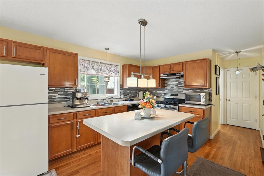 82 Lloyd Avenue Springfield, MA 01119 - Photo 11 of 32 a kitchen with a refrigerator a stove a sink dishwasher a oven with a dining table and chairs