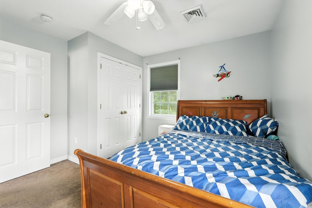 82 Lloyd Avenue Springfield, MA 01119 - Photo 19 of 32 a bedroom with a large bed and a chandelier