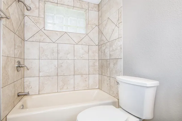 a bathroom with a toilet and a bath tub