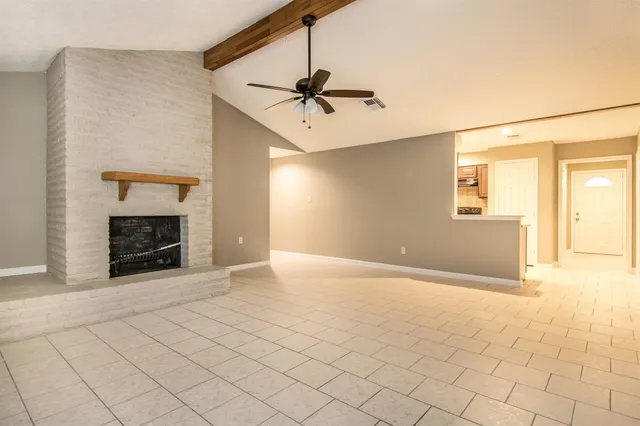 an empty room with windows and fireplace