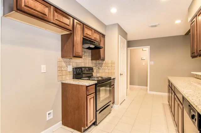 a kitchen with stainless steel appliances granite countertop a stove and a refrigerator