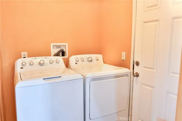 a view of a kitchen with fridge and wooden floor