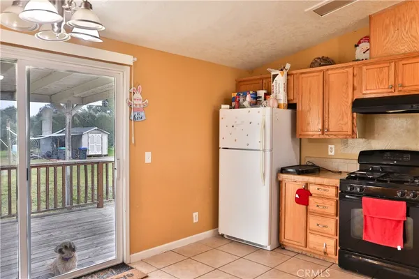 a view of a kitchen with fridge and wooden floor