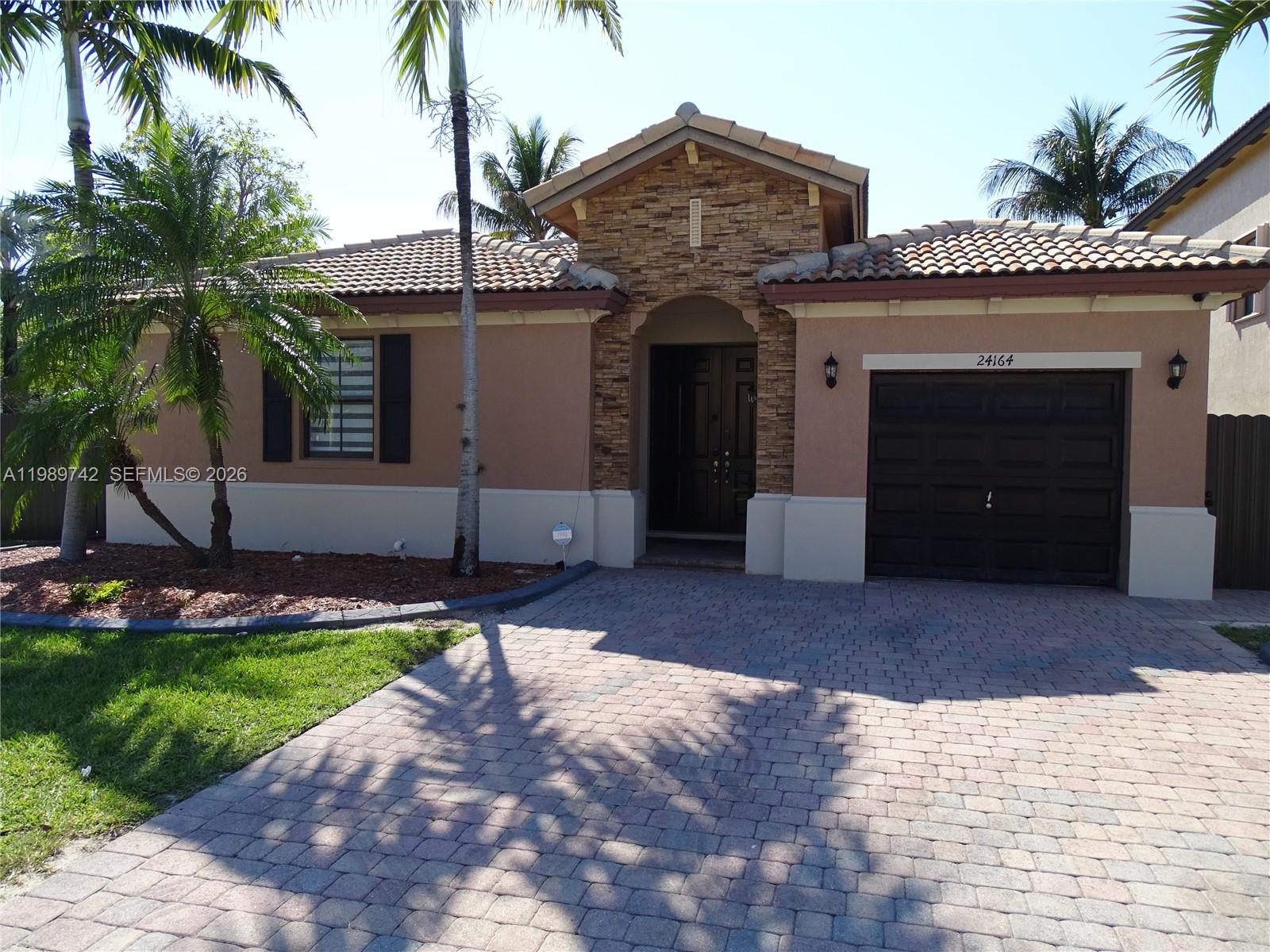 24164 Southwest 113th Path Homestead, FL 33032 - Photo 1 of 68 a front view of a house with a yard and garage