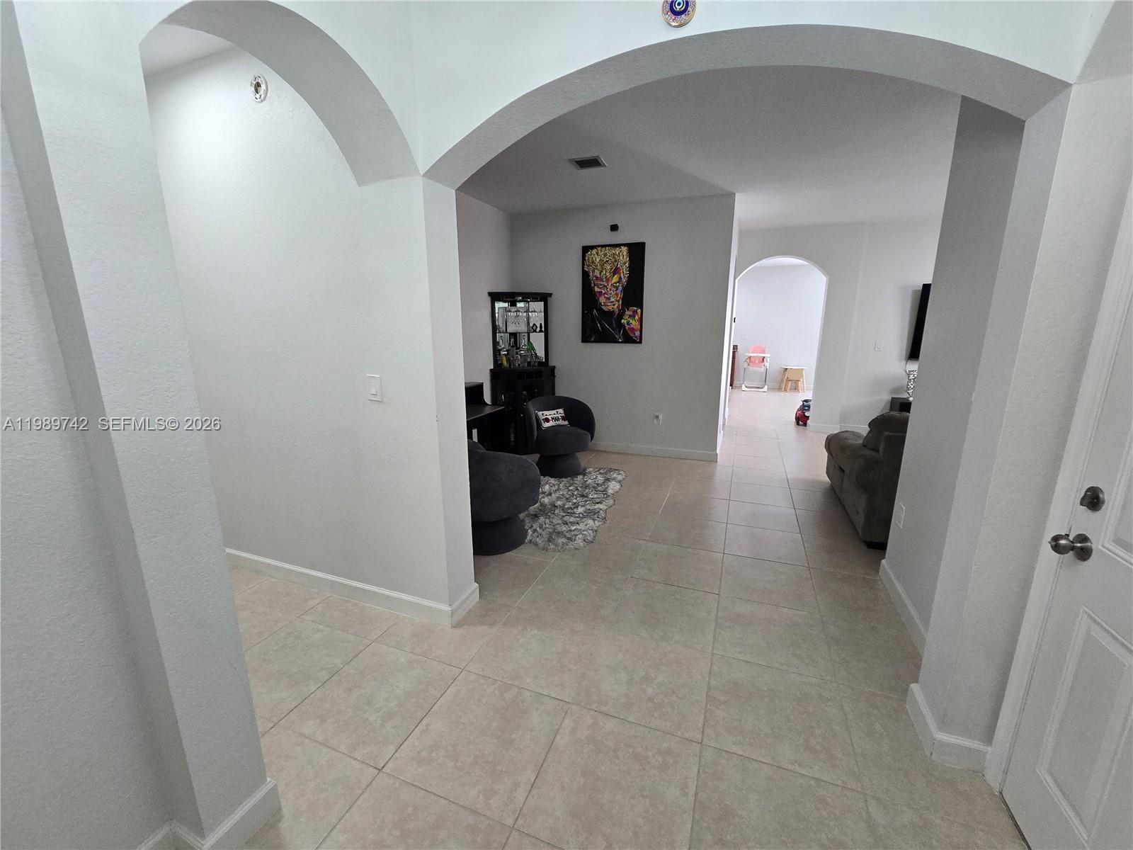 24164 Southwest 113th Path Homestead, FL 33032 - Photo 14 of 68 a view of a hallway to a livingroom and a livingroom with furniture