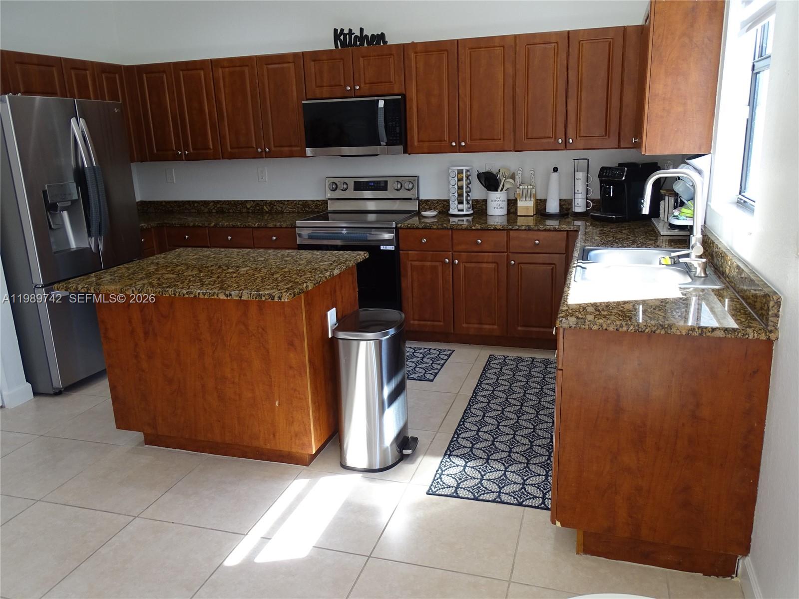 24164 Southwest 113th Path Homestead, FL 33032 - Photo 18 of 68 a kitchen with stainless steel appliances granite countertop a stove a sink a microwave a refrigerator and cabinets