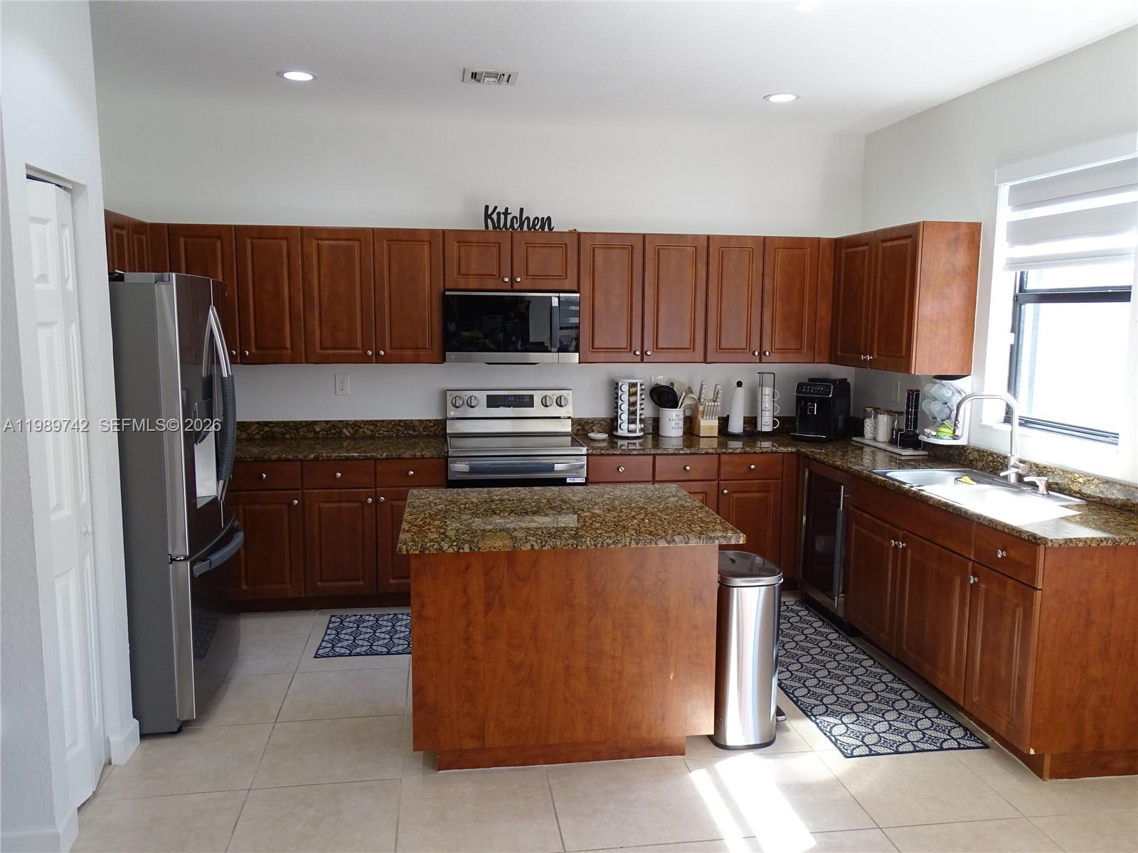 24164 Southwest 113th Path Homestead, FL 33032 - Photo 19 of 68 a kitchen with stainless steel appliances granite countertop a refrigerator a stove a sink a microwave and a refrigerator