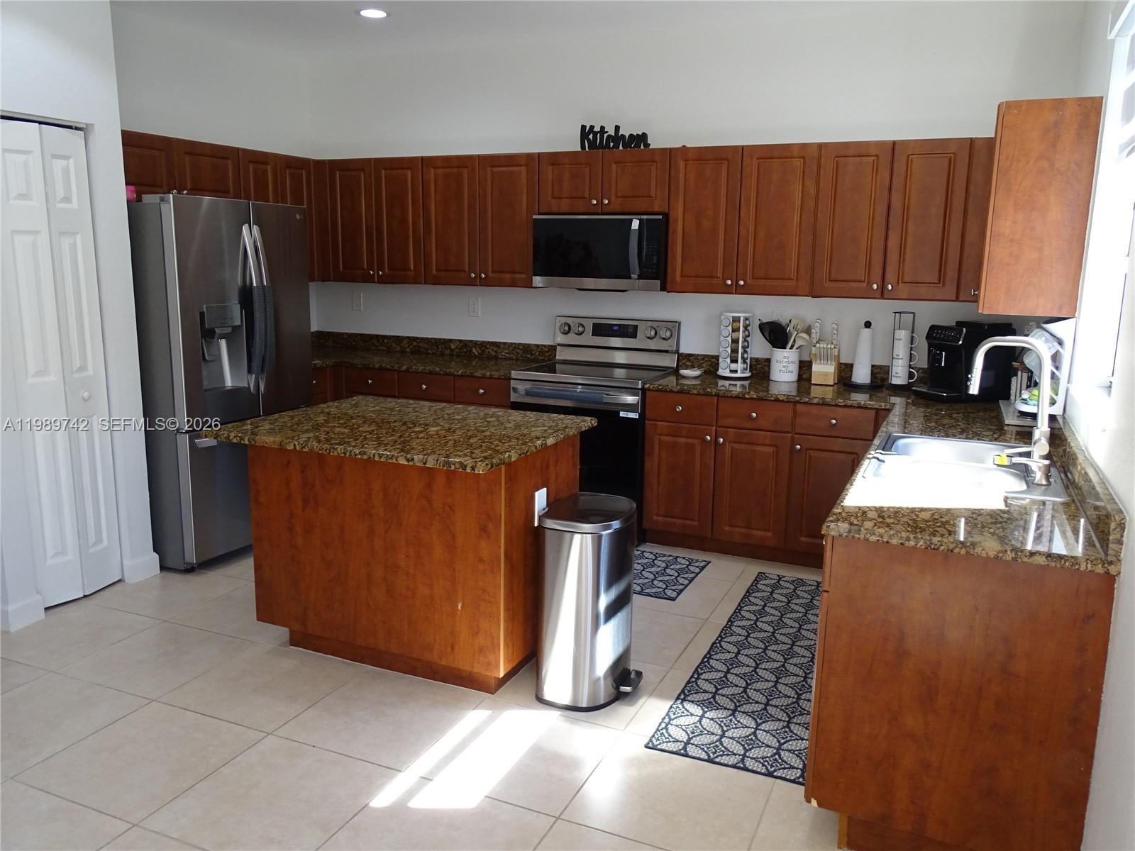 24164 Southwest 113th Path Homestead, FL 33032 - Photo 20 of 68 a kitchen with stainless steel appliances granite countertop a refrigerator stove and a sink