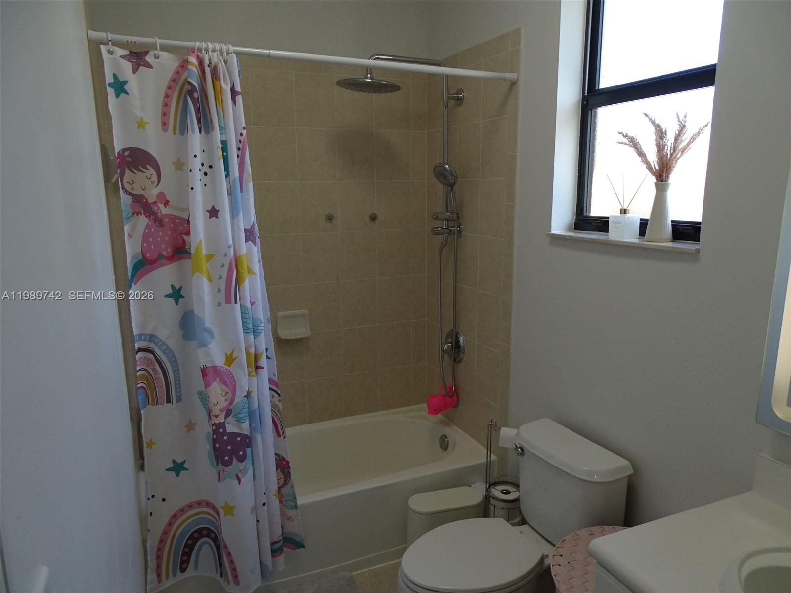 24164 Southwest 113th Path Homestead, FL 33032 - Photo 29 of 68 a bathroom with a toilet and a shower curtain