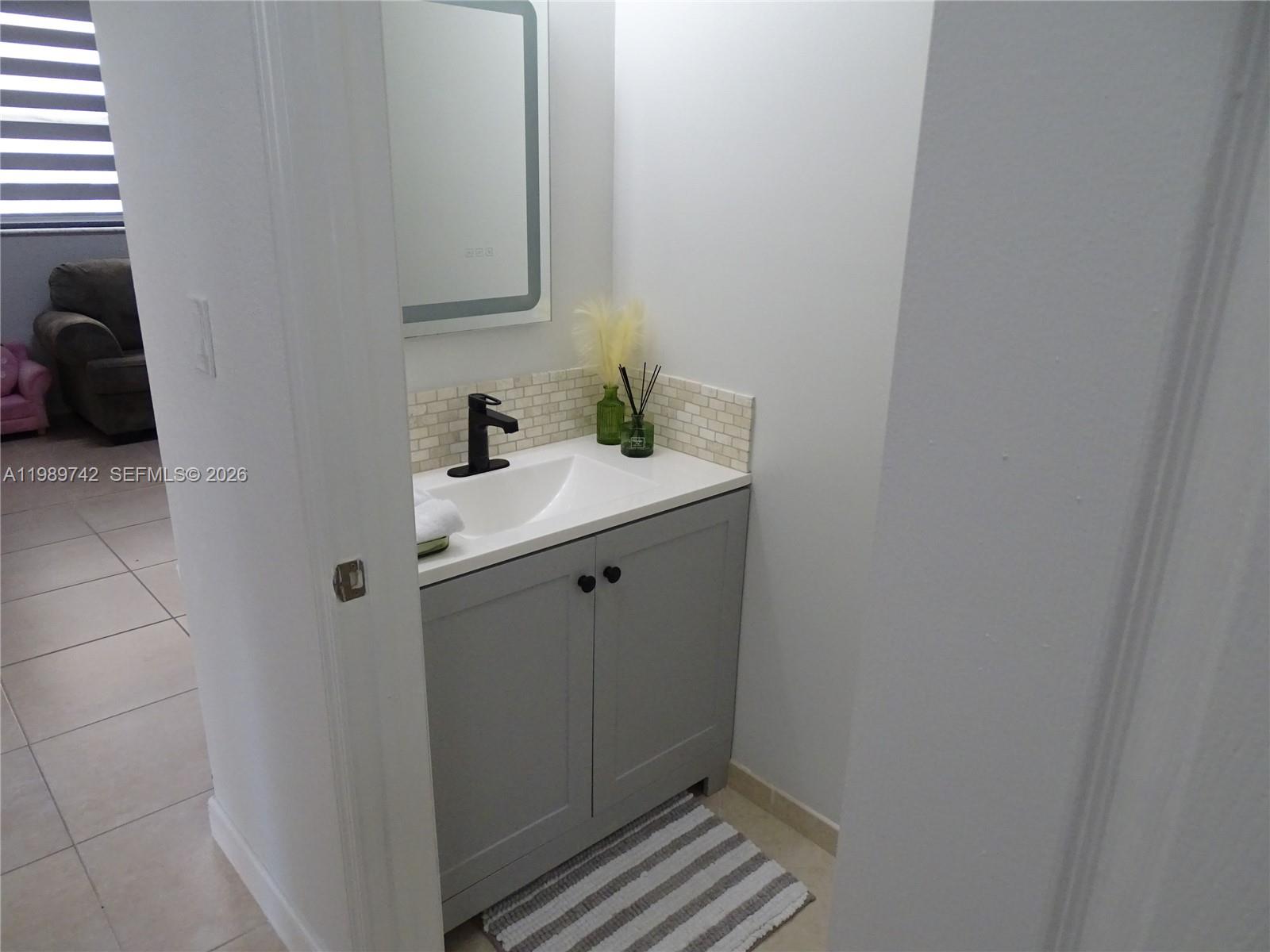 24164 Southwest 113th Path Homestead, FL 33032 - Photo 36 of 68 a bathroom with a sink and a mirror