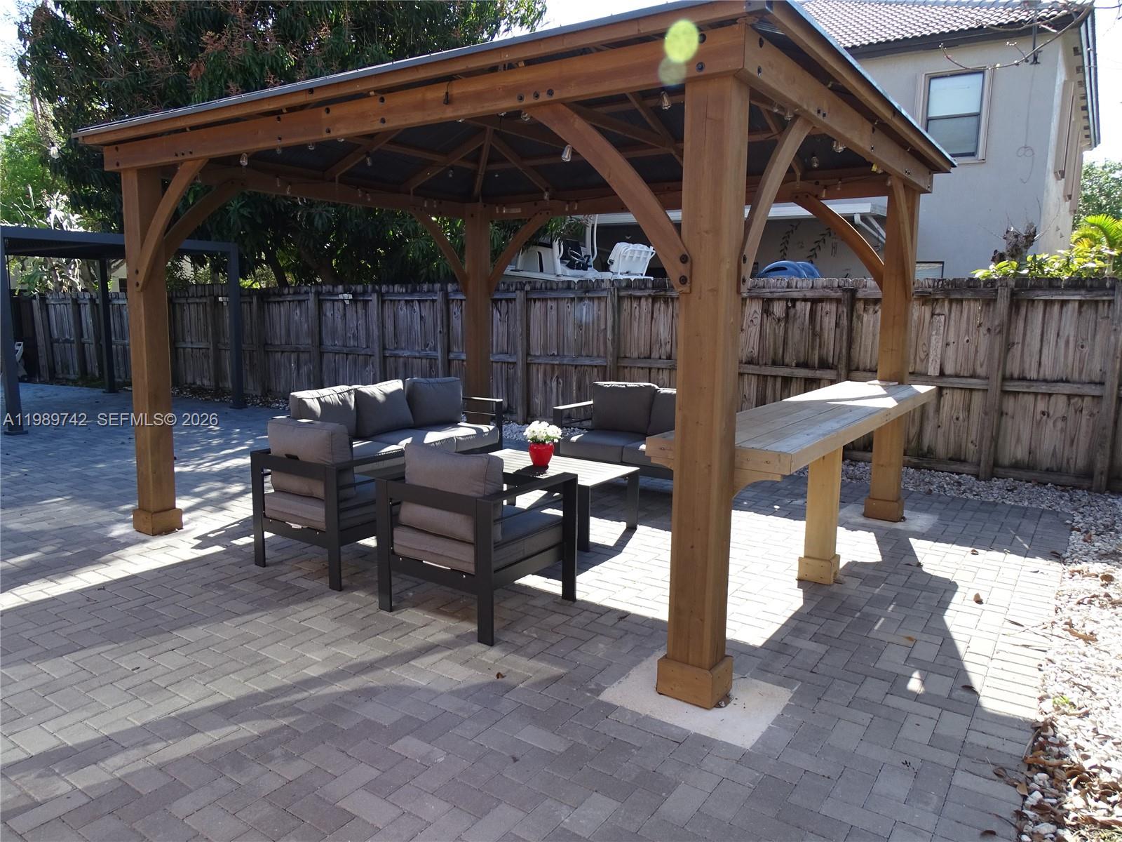 24164 Southwest 113th Path Homestead, FL 33032 - Photo 52 of 68 a view of a patio with table and chairs with wooden fence