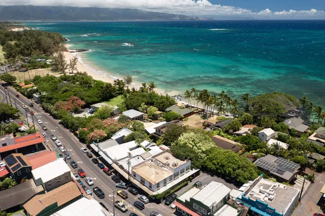 an aerial view of residential houses with outdoor space and trees
