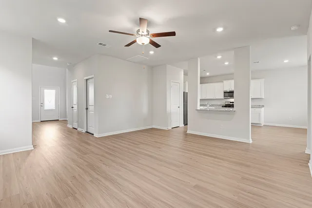 a large kitchen with stainless steel appliances and white cabinets