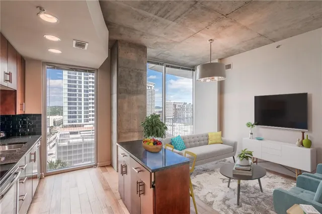 a living room with furniture a flat screen tv and a large window