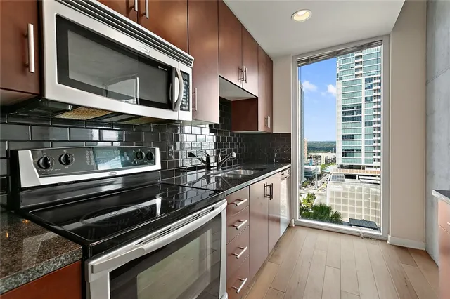 a kitchen with granite countertop a stove microwave and sink